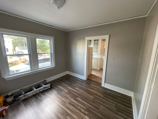 unfurnished room with baseboards, dark wood finished floors, and crown molding