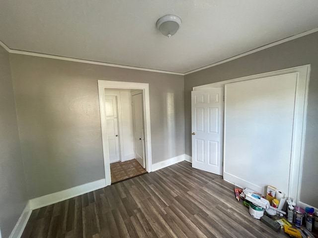 unfurnished bedroom featuring baseboards, dark wood finished floors, and ornamental molding