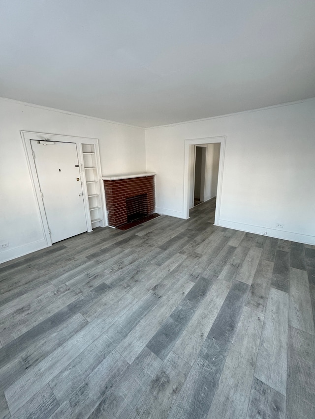 unfurnished living room with a fireplace, wood finished floors, and baseboards