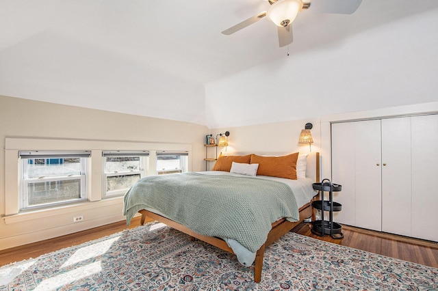 bedroom featuring a closet, wood finished floors, a ceiling fan, and vaulted ceiling