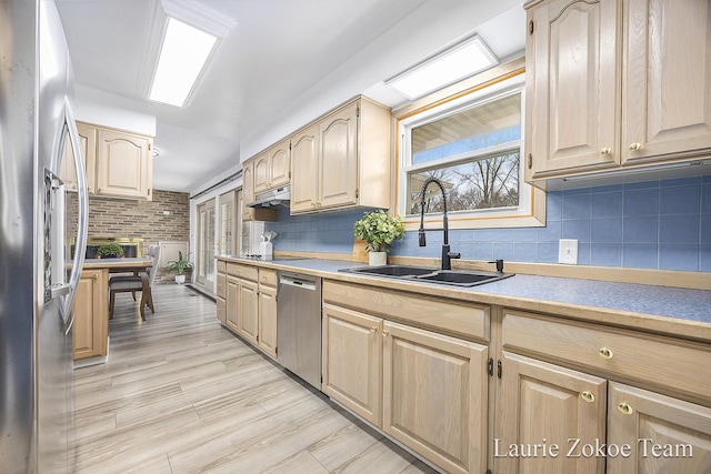 kitchen with a sink, decorative backsplash, appliances with stainless steel finishes, and light brown cabinets