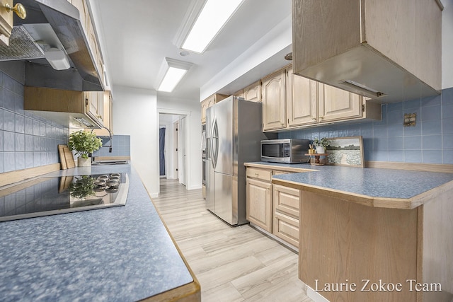 kitchen with decorative backsplash, light wood-style flooring, exhaust hood, and stainless steel appliances