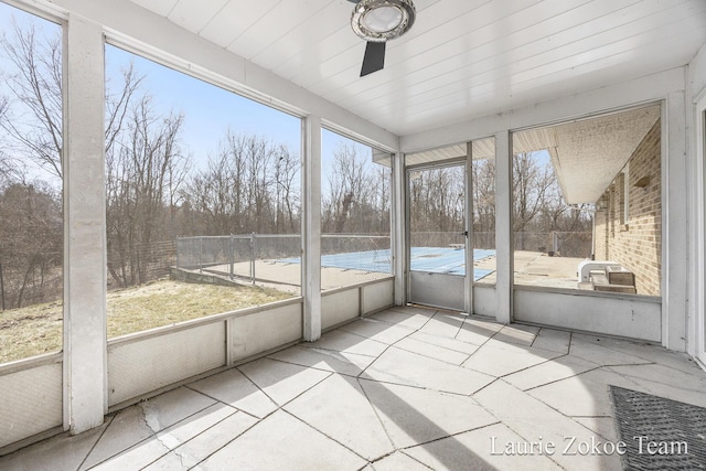 unfurnished sunroom featuring ceiling fan