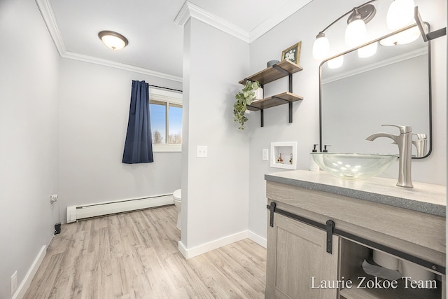 bathroom with toilet, ornamental molding, wood finished floors, vanity, and a baseboard radiator