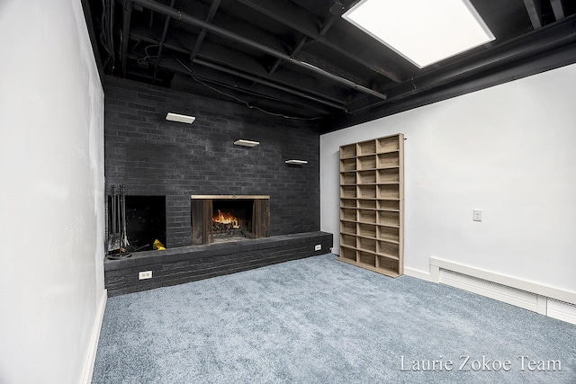 basement featuring a brick fireplace and carpet