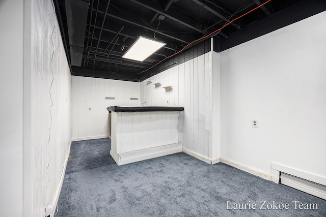 finished basement featuring a baseboard heating unit and carpet