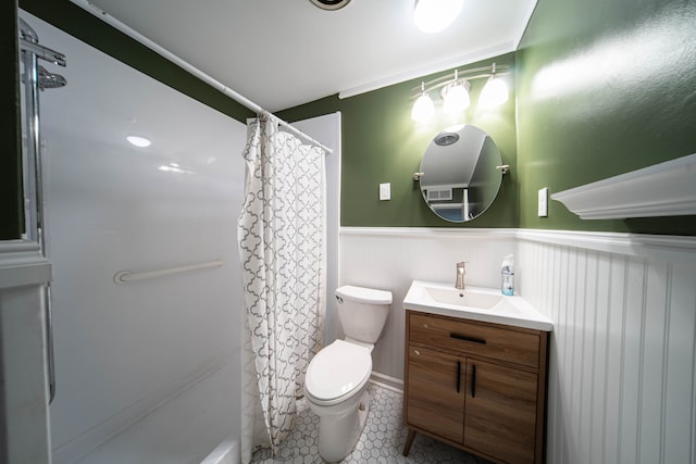 bathroom with a wainscoted wall, toilet, a shower with shower curtain, tile patterned flooring, and vanity