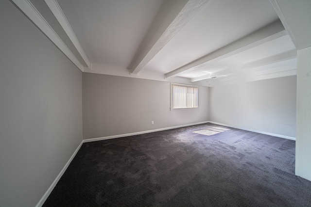 empty room with beam ceiling, baseboards, and dark colored carpet