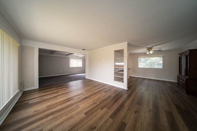 interior space with a ceiling fan, baseboards, and dark wood-style flooring