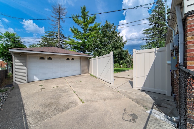 detached garage with a gate and fence