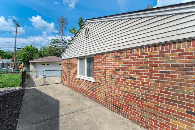 view of home's exterior featuring a gate, an outbuilding, a garage, and fence