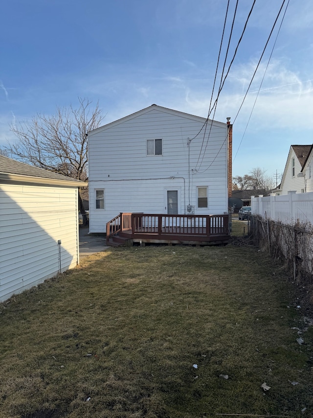 rear view of house with a yard, fence, and a wooden deck