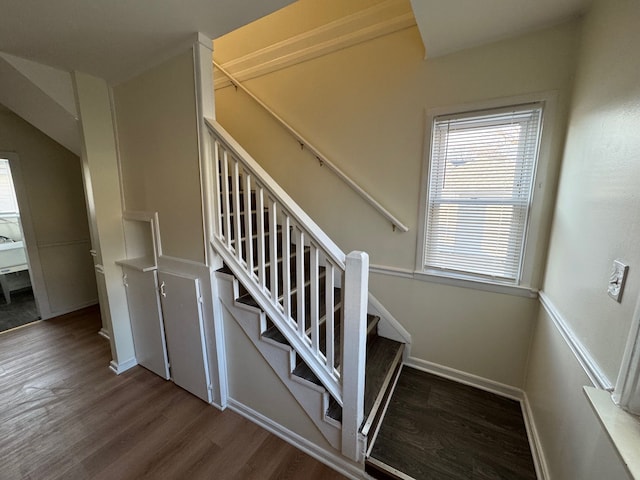 stairway with wood finished floors and baseboards