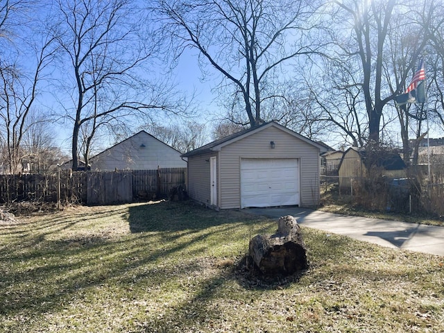 detached garage with concrete driveway and fence