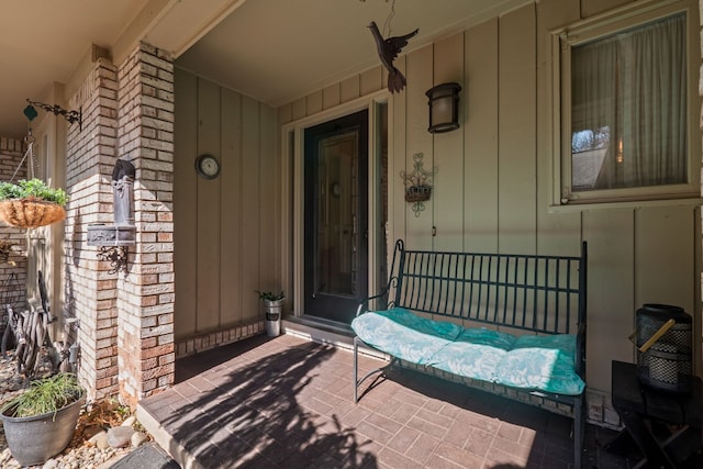 doorway to property with brick siding and board and batten siding