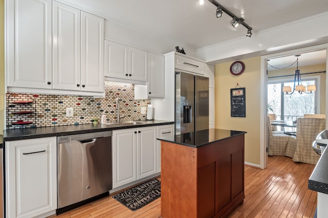 kitchen with dark countertops, stainless steel appliances, and a sink