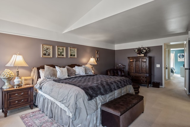 bedroom featuring light colored carpet, baseboards, and vaulted ceiling