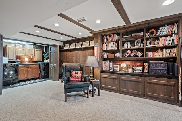 living area with wooden walls, visible vents, washer / dryer, and carpet