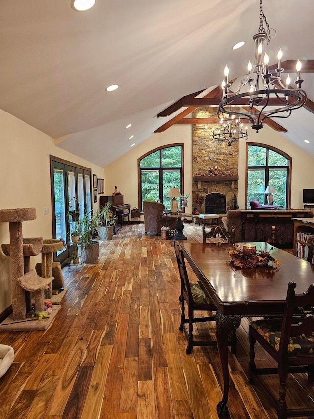 dining room featuring vaulted ceiling with beams, recessed lighting, a fireplace, french doors, and wood finished floors