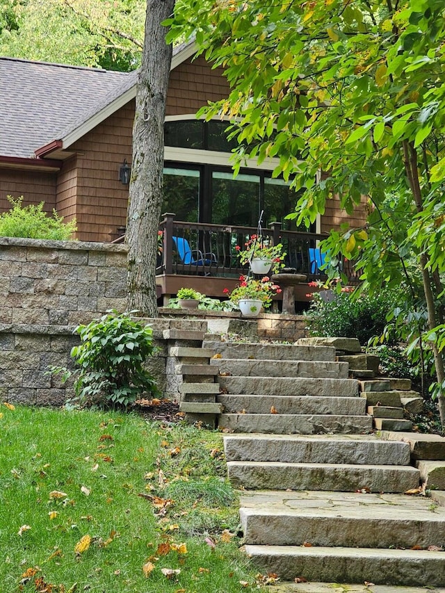 exterior space featuring stairway and a shingled roof