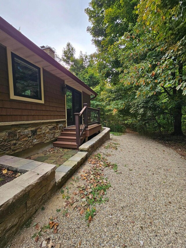 view of yard featuring a wooden deck and driveway