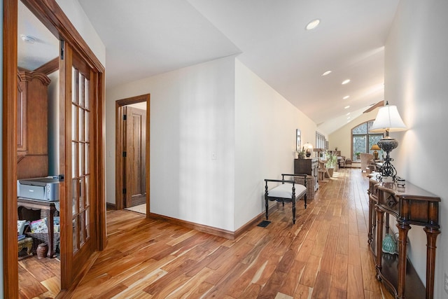corridor with baseboards, vaulted ceiling, recessed lighting, light wood-style floors, and visible vents