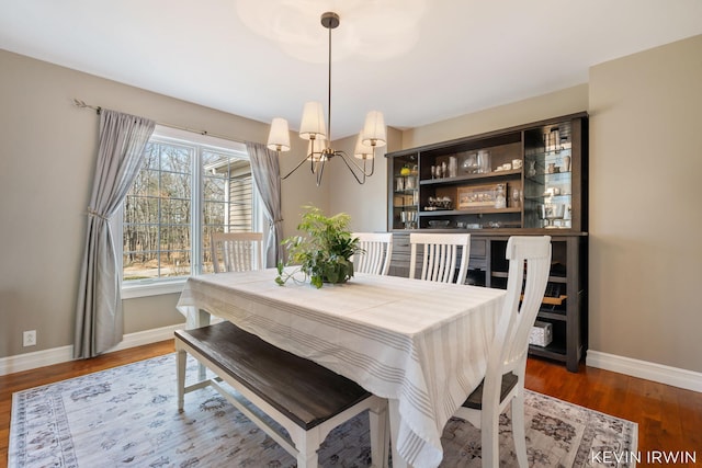 dining room featuring wood finished floors, baseboards, and a chandelier