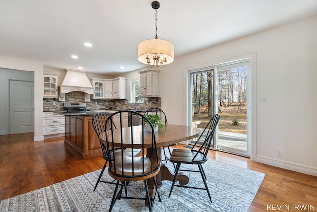 dining space featuring a chandelier, recessed lighting, baseboards, and wood finished floors