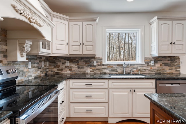 kitchen with a sink, dark stone countertops, backsplash, and stainless steel appliances