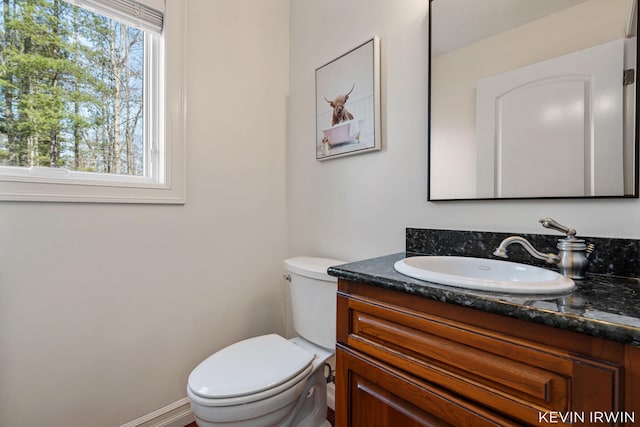 bathroom with vanity, toilet, and baseboards