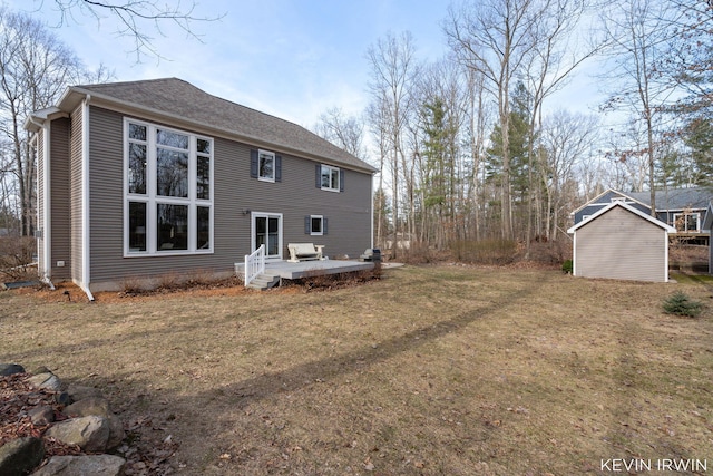 rear view of house with a lawn, a deck, and a shingled roof