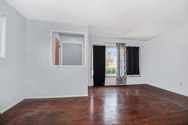 spare room featuring baseboards and hardwood / wood-style floors