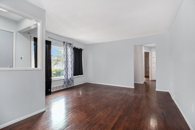 unfurnished room with baseboards, visible vents, and wood-type flooring