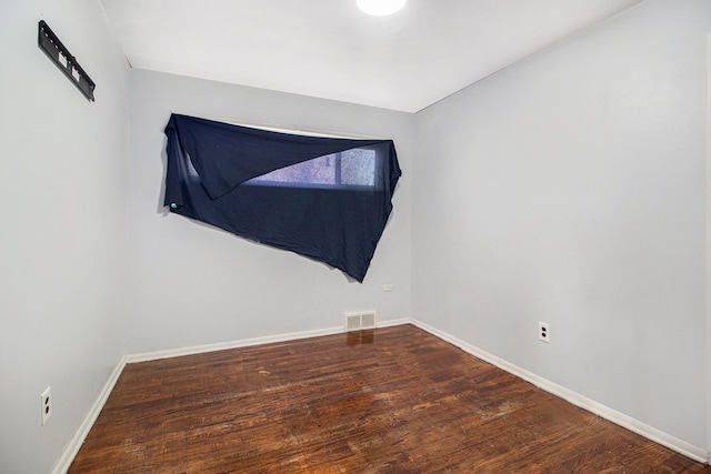 unfurnished room with visible vents, baseboards, and wood finished floors