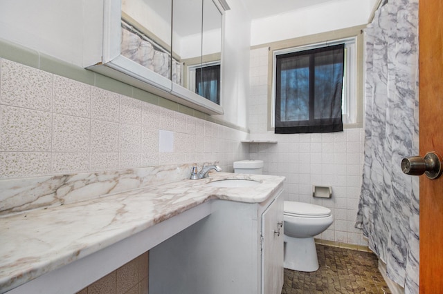 bathroom with vanity, tile walls, and toilet