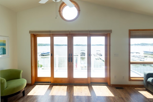 doorway with lofted ceiling, wood finished floors, visible vents, and a water view