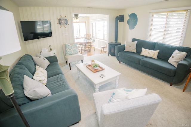 living area with a wood stove and carpet