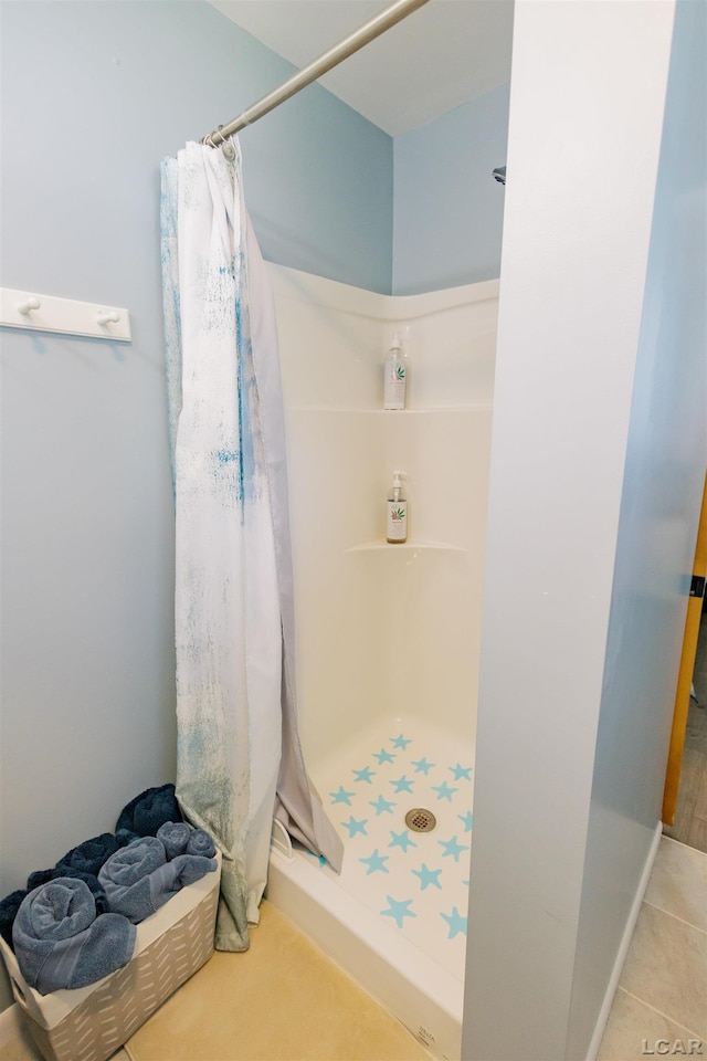 full bathroom featuring tile patterned flooring and a stall shower