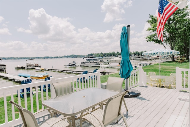 deck featuring outdoor dining space, a water view, and a boat dock