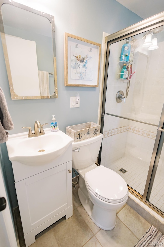 bathroom with a stall shower, toilet, and vanity