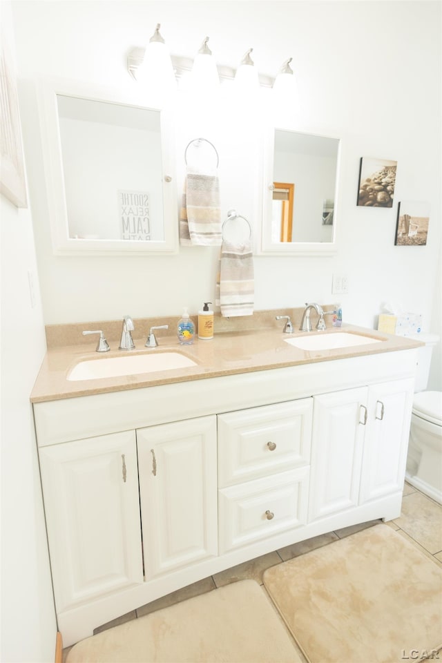 full bath featuring double vanity, toilet, and a sink