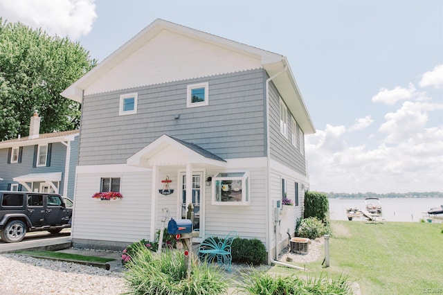 back of house with cooling unit and a lawn