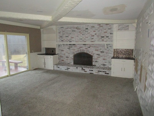 unfurnished living room featuring carpet floors and a brick fireplace