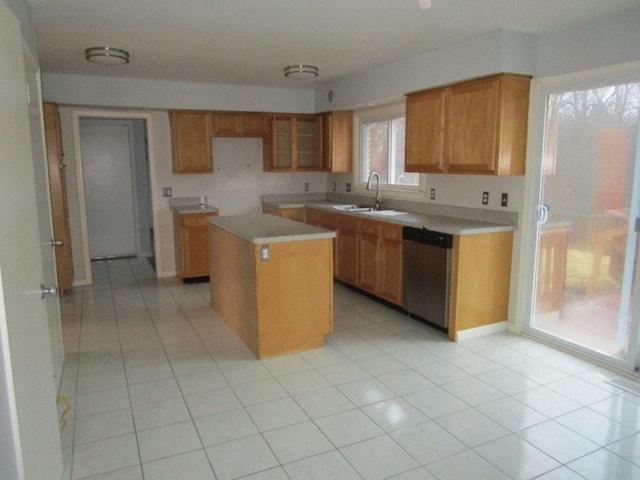 kitchen featuring dishwasher, a center island, light countertops, and a sink