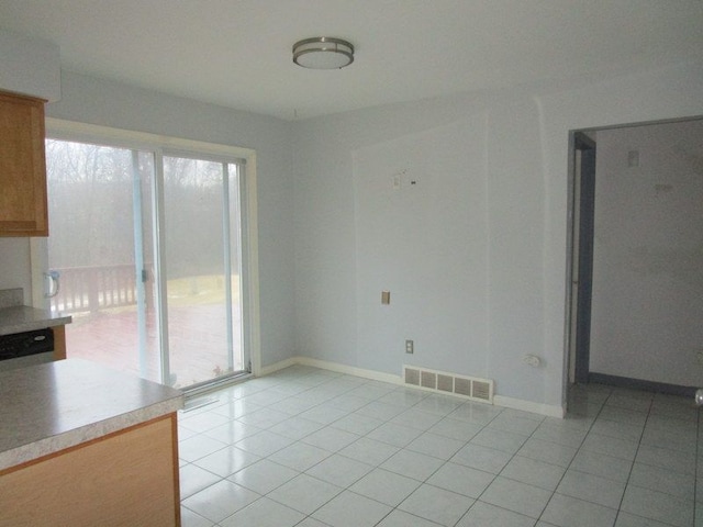 spare room featuring light tile patterned floors, baseboards, and visible vents