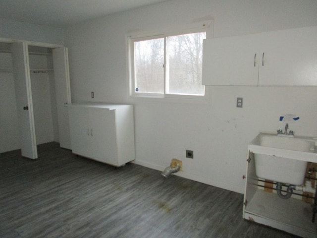 washroom featuring laundry area, a sink, baseboards, and wood finished floors