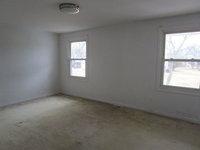 unfurnished room featuring baseboards and carpet