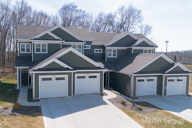 view of front of home with a garage, driveway, and a shingled roof