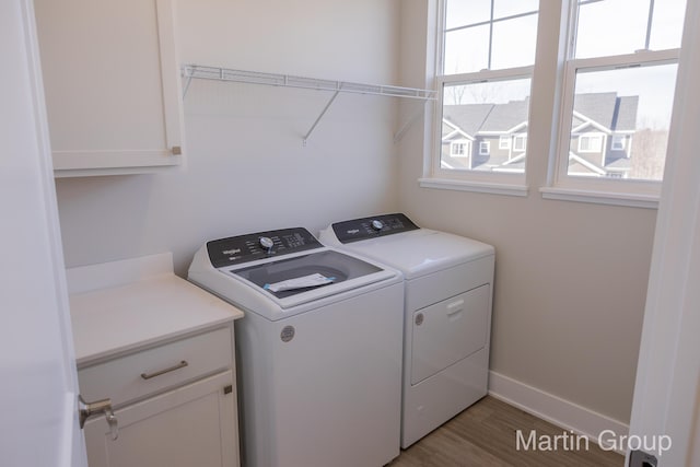 laundry room with washer and dryer, wood finished floors, cabinet space, and baseboards