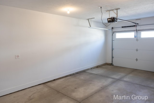 garage featuring a garage door opener and baseboards